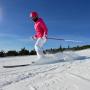 woman in pink winter jacket and helmet skiing 